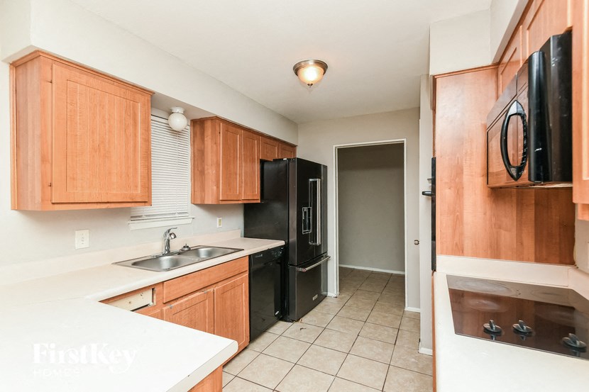 a kitchen with wooden cabinets and a black refrigerator
