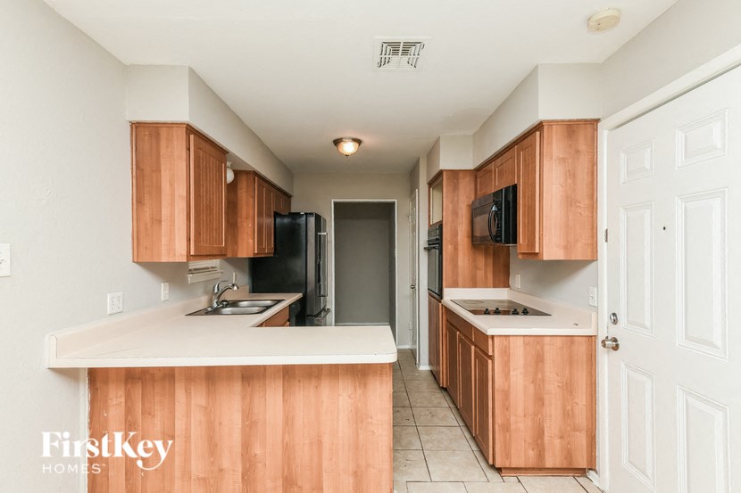 a kitchen with wooden cabinets and a white counter top