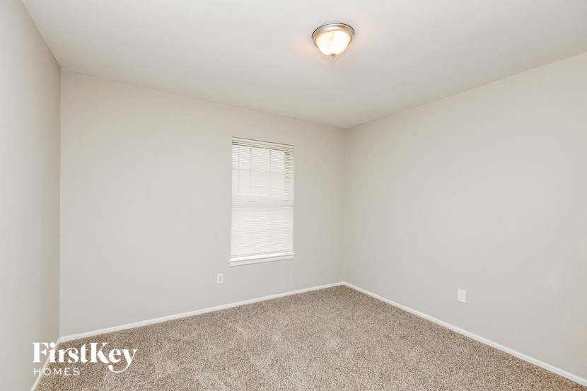 a bedroom with a carpeted floor and a window
