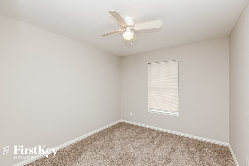 a bedroom with a ceiling fan and a window