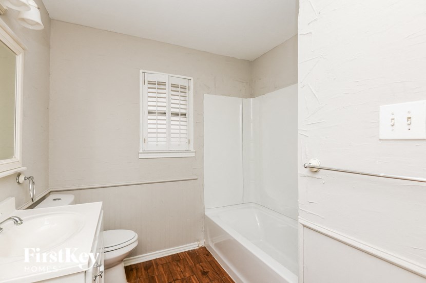 a bathroom with a toilet and a tub and a sink