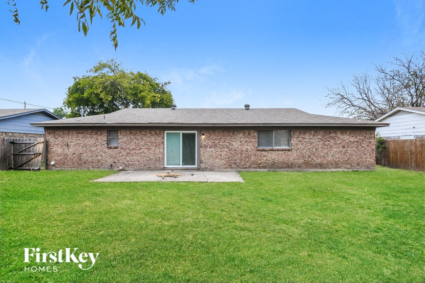 a brick home with green grass and a yard