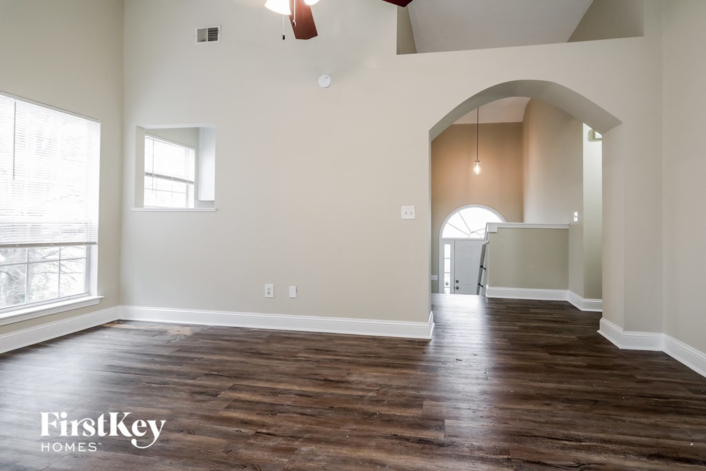 A room with wooden floors and a large arched doorway.