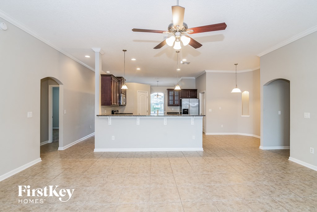an open kitchen and living room with a ceiling fan