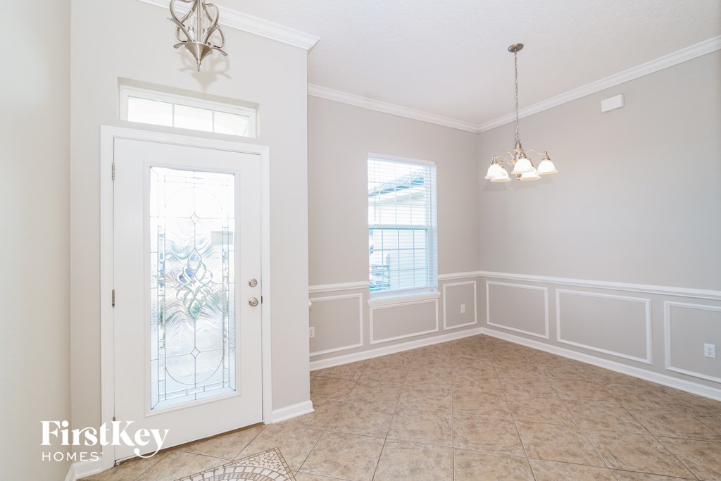 an empty dining room with white walls and a glass door