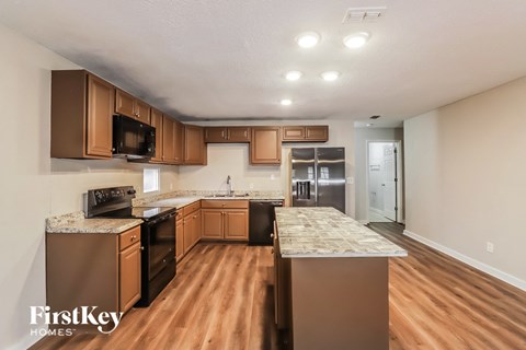 a kitchen with wooden cabinets and stainless steel appliances and marble counter tops