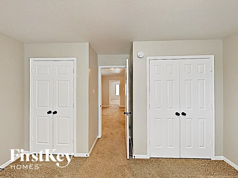 a bedroom with two white doors and a hallway to a closet