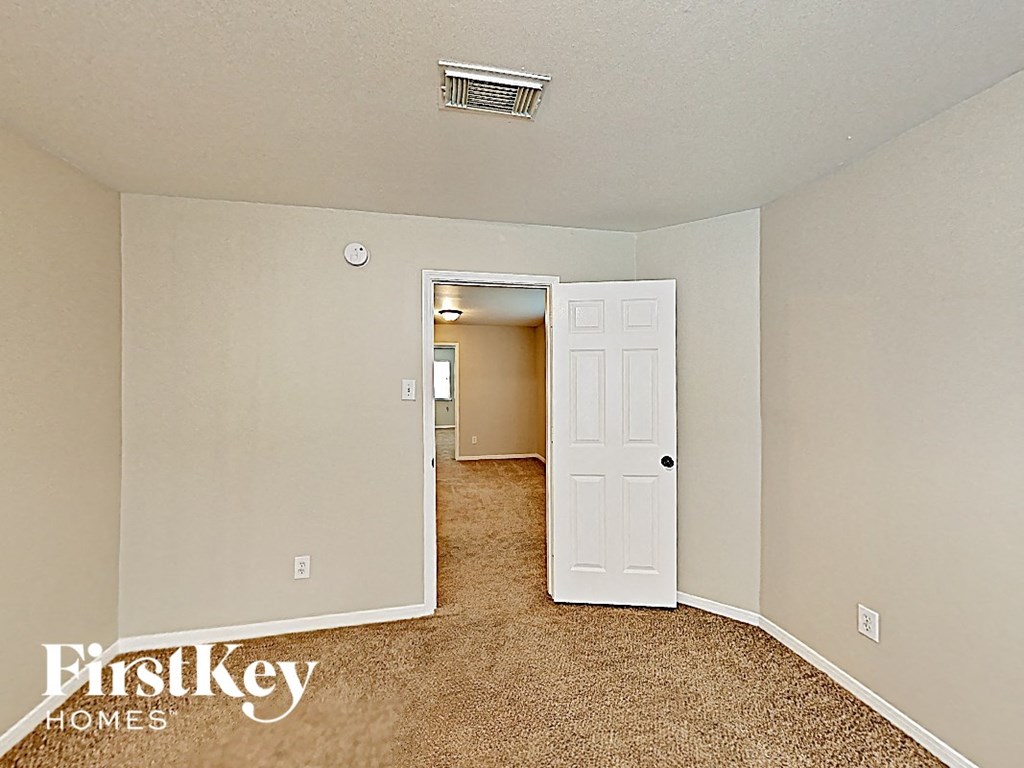 a bedroom with a white door and a carpeted floor