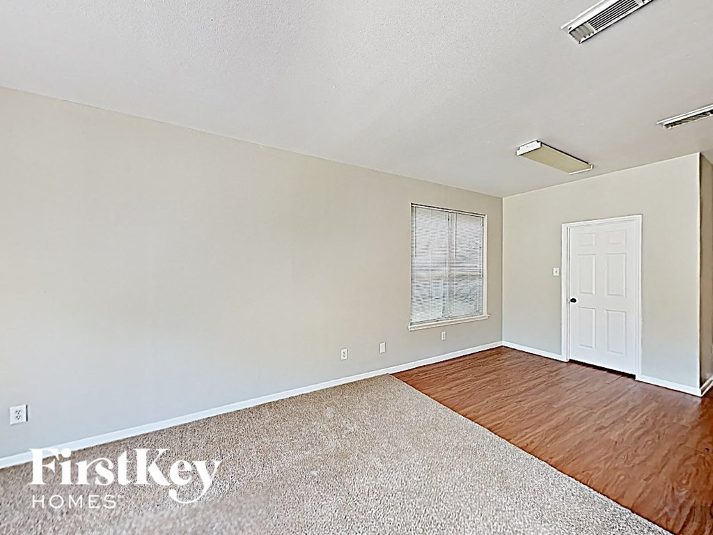 an empty living room with wood flooring and a white door