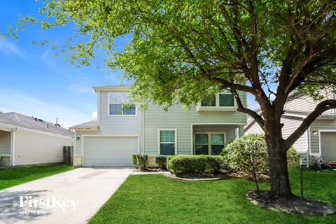 A tree in front of a house with the words "FirstKey Homes" on the bottom left.