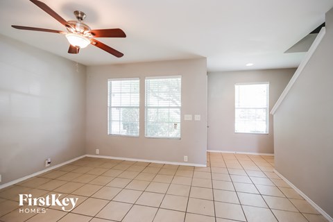 A spacious room with a ceiling fan and tiled flooring.