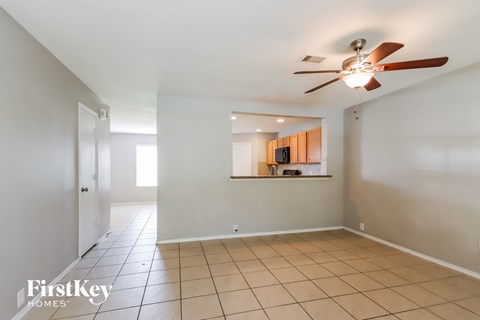 A spacious room with a ceiling fan and tiled flooring.
