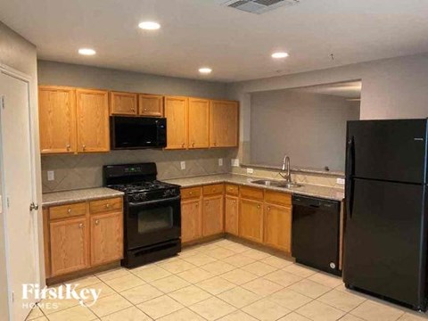 a kitchen with black appliances and wooden cabinets