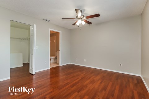 an empty living room with wood flooring and a ceiling fan