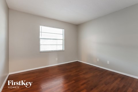 the living room with wood floors and a window