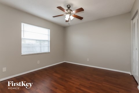 a living room with wood floors and a ceiling fan