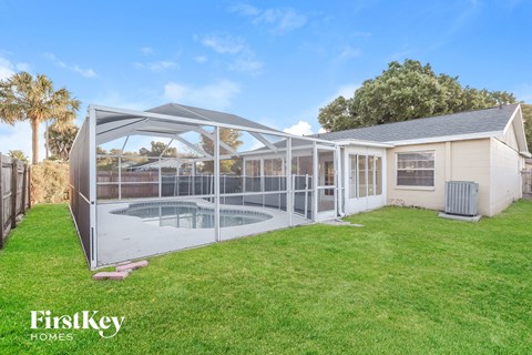 the backyard of a house with a pool and a greenhouse
