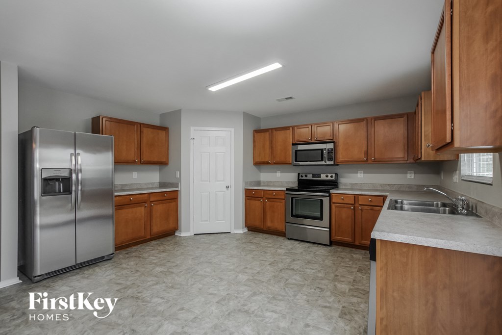 A kitchen with wooden cabinets and a stainless steel refrigerator.