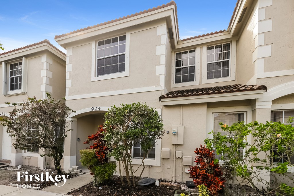 the front of a house with trees and a sidewalk