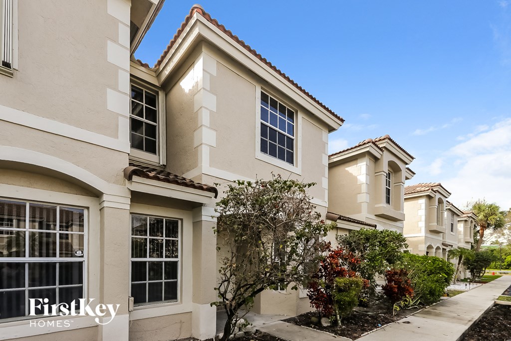 a row of townhomes with a sidewalk and trees in front of them