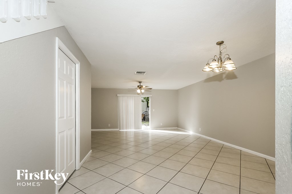 an empty living room with tiled floors and a white door