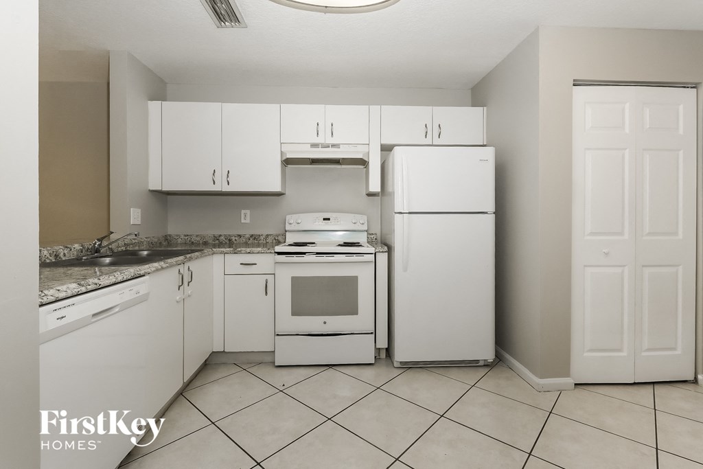 a kitchen with white appliances and white cabinets