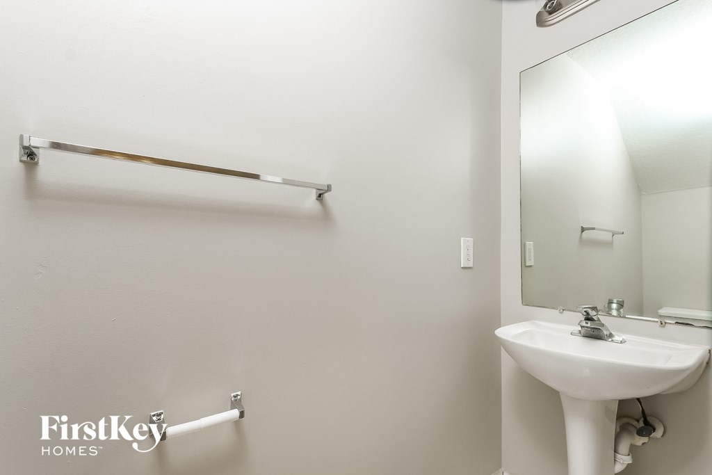 a bathroom with a sink and a mirror and a towel rack