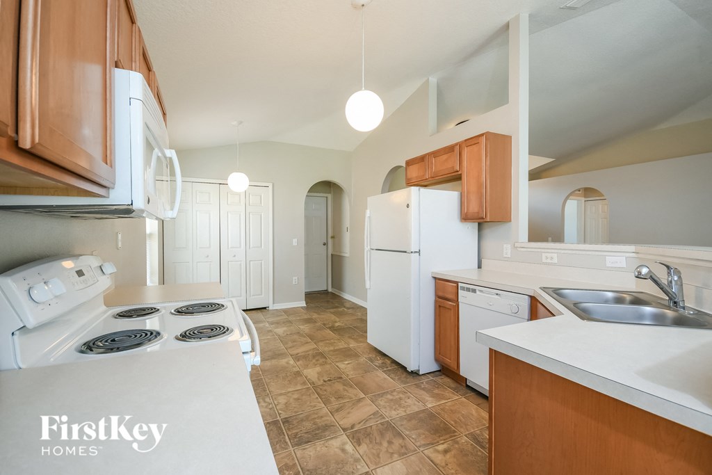 a kitchen with white appliances and wooden cabinets