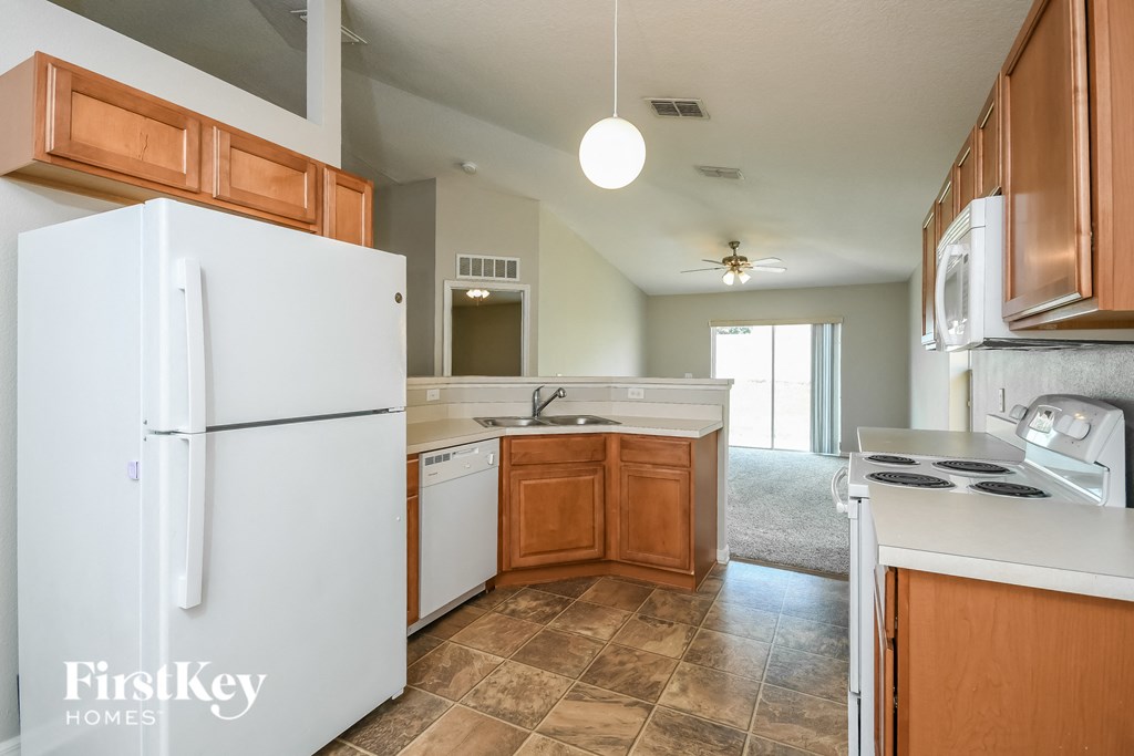 a kitchen with white appliances and wooden cabinets