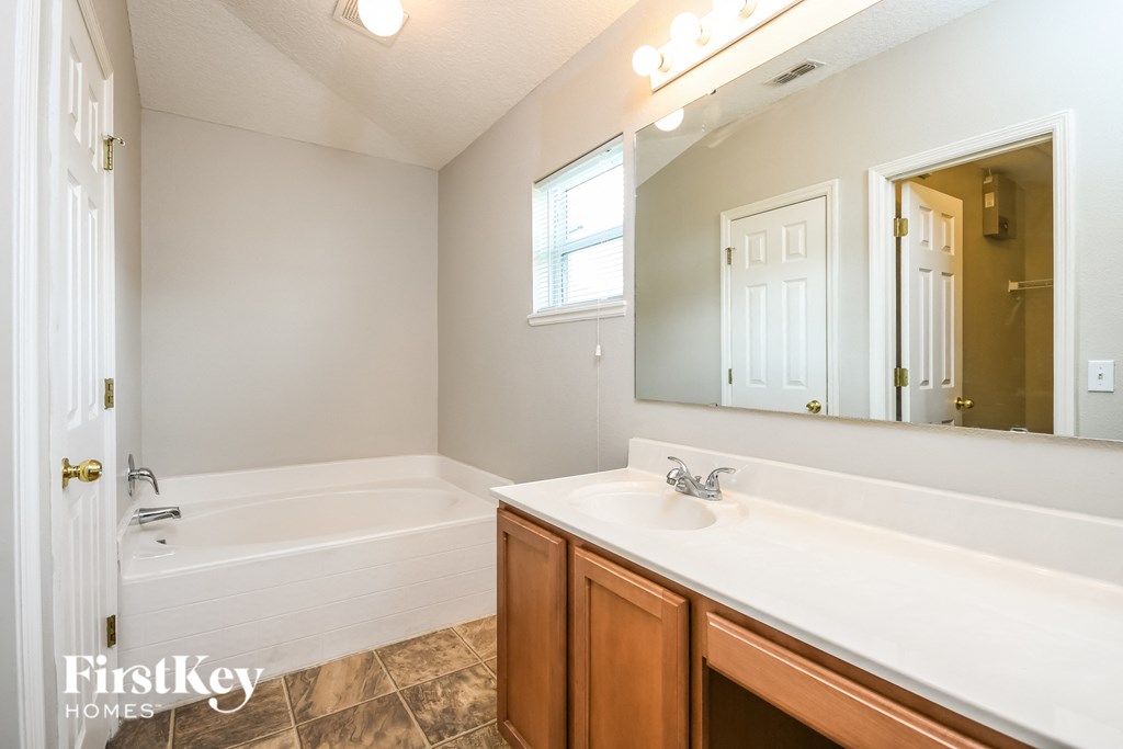 a bathroom with a sink and a tub and a mirror