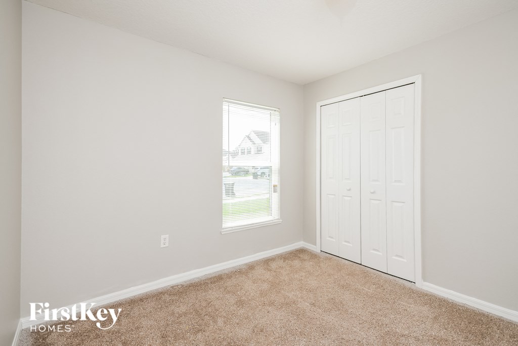 a bedroom with a closet and a door and a window