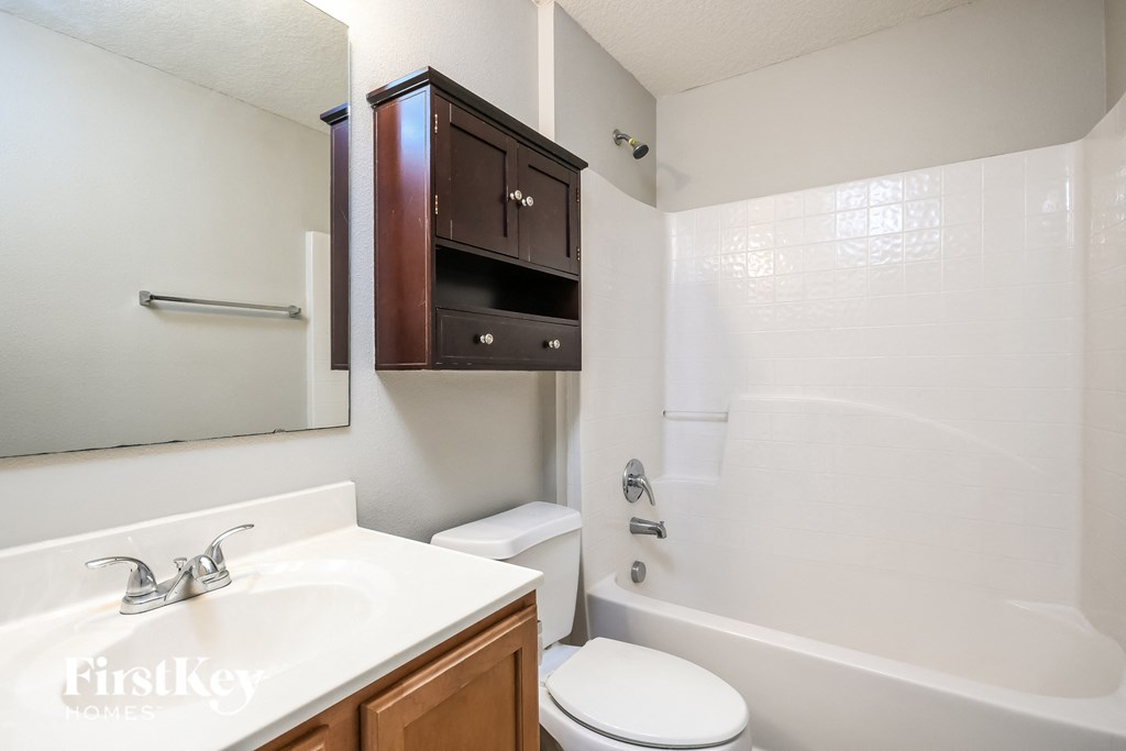 a bathroom with a sink toilet and shower and a mirror