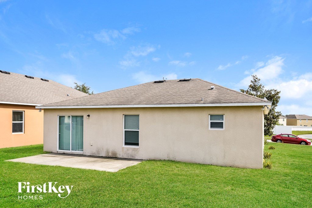 a white house with a green lawn and a blue sky