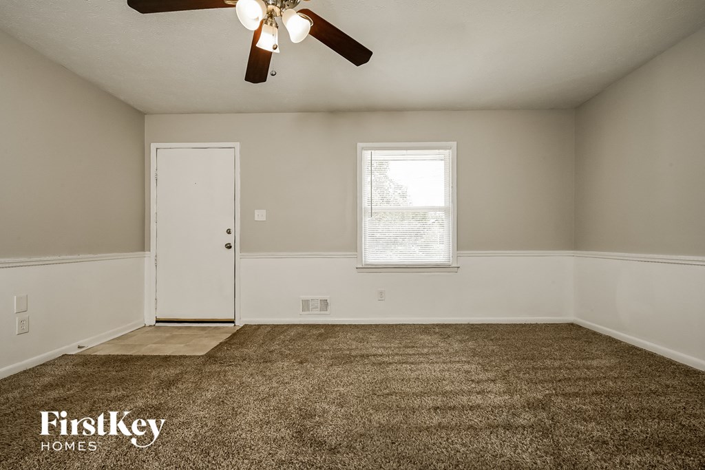 the living room of an empty house with a ceiling fan
