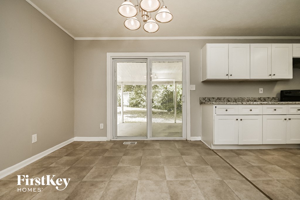 a kitchen with white cabinets and a sliding glass door
