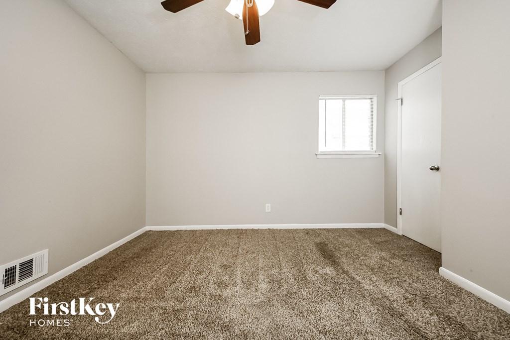 the spacious living room with carpeting and a ceiling fan