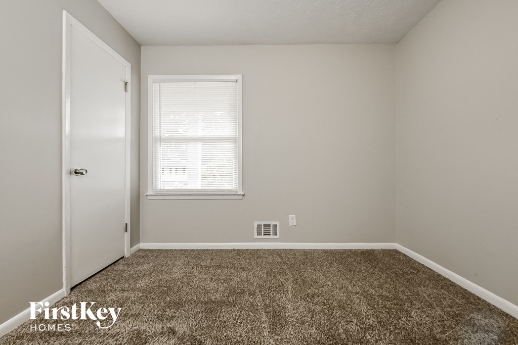 a bedroom with a carpeted floor and a white door