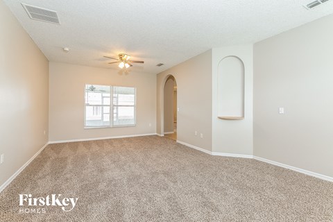 a spacious living room with carpet and a window