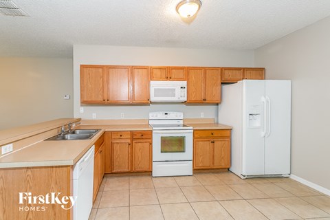 a kitchen with white appliances and wooden cabinets