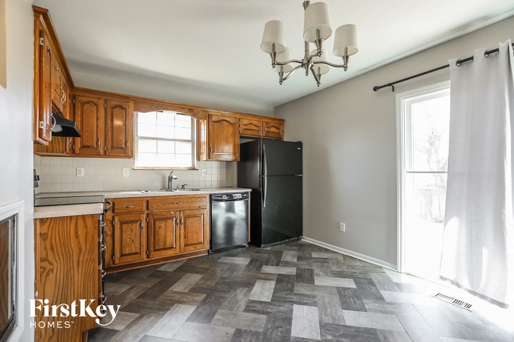 a kitchen with wooden cabinets and a black refrigerator
