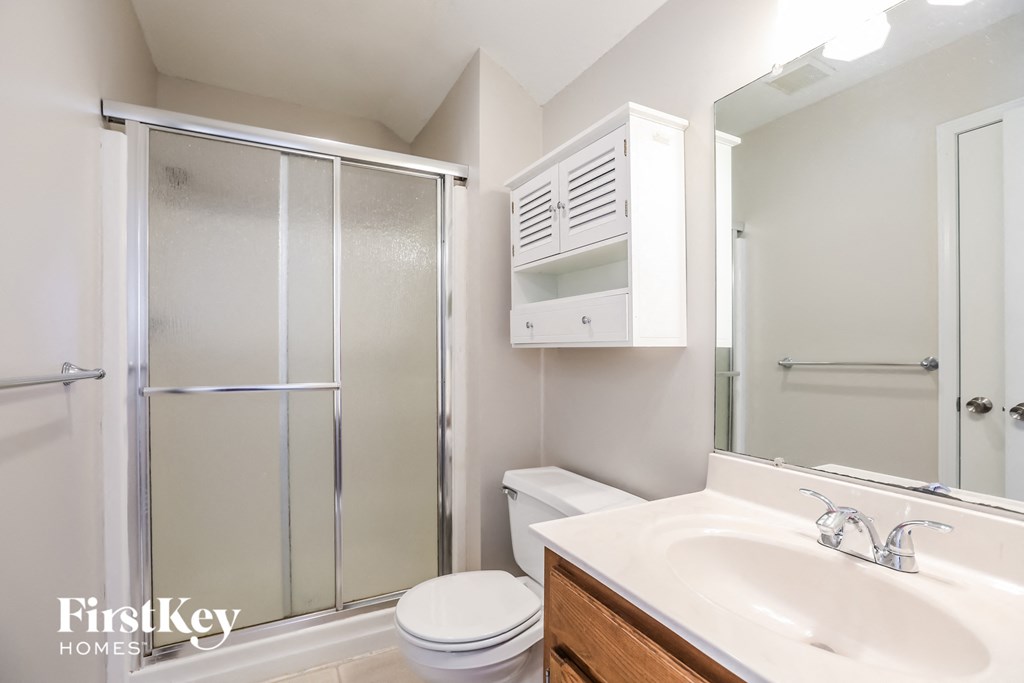 a bathroom with a shower sink and toilet and a mirror