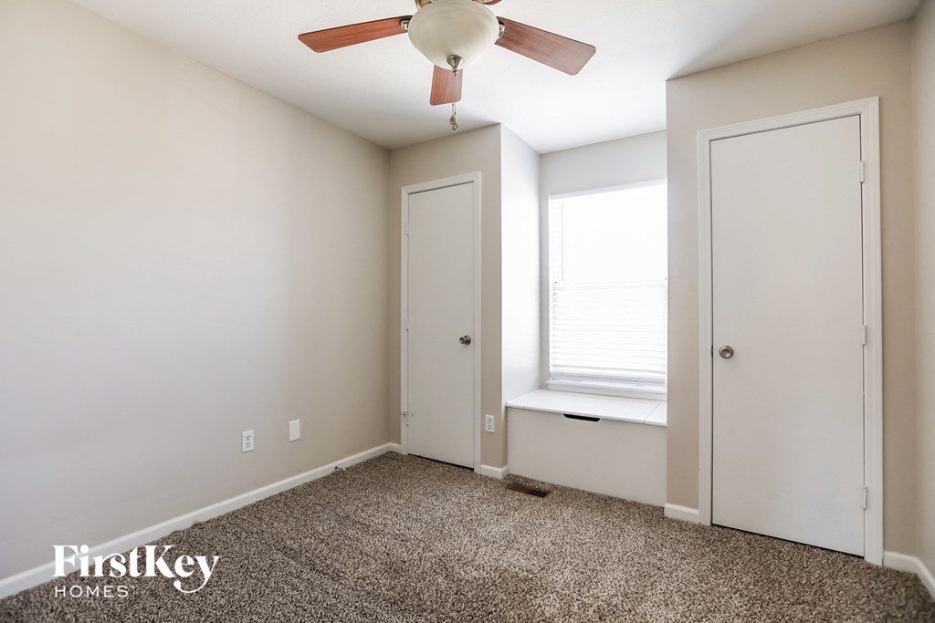 a bedroom with a ceiling fan and a window