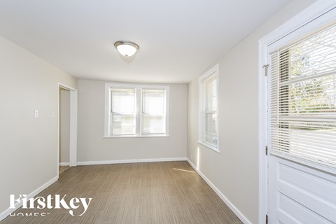a bedroom with white walls and a white door and window