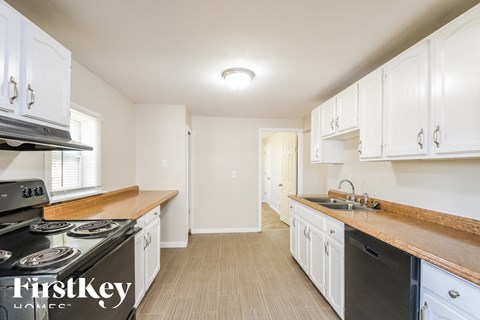 a kitchen with white cabinets and a stove and a sink