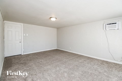A room with a carpeted floor and a door.