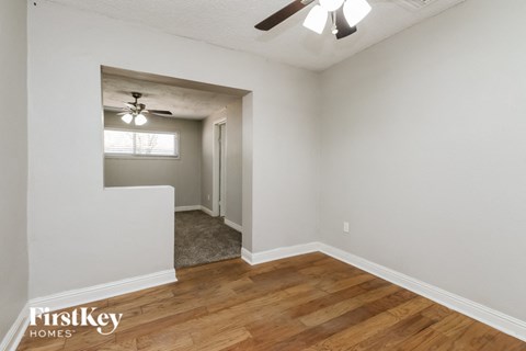 A room with wooden floors and a ceiling fan.