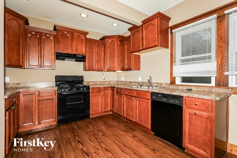A kitchen with wooden cabinets and a black stove top oven.