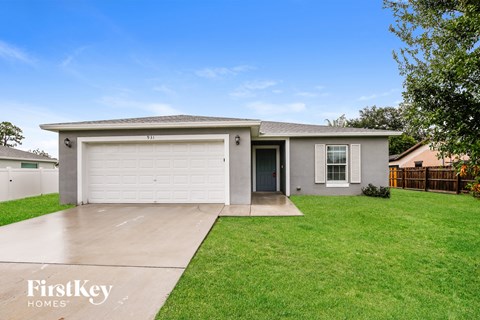 A house with a garage and a driveway in front of it.