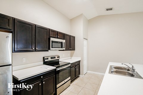 A kitchen with black cabinets and stainless steel appliances.