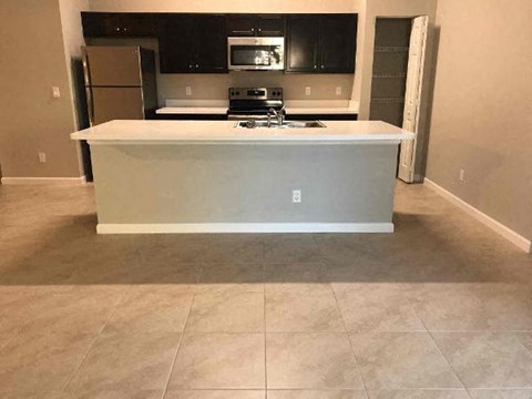 A kitchen island with a countertop and a microwave above it.